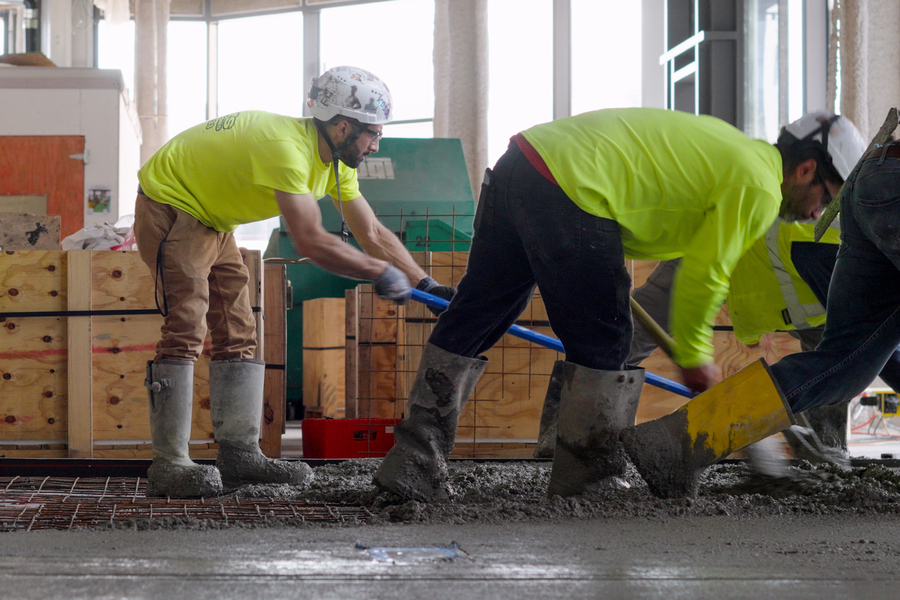 Alt text: Workers spreading wet cement